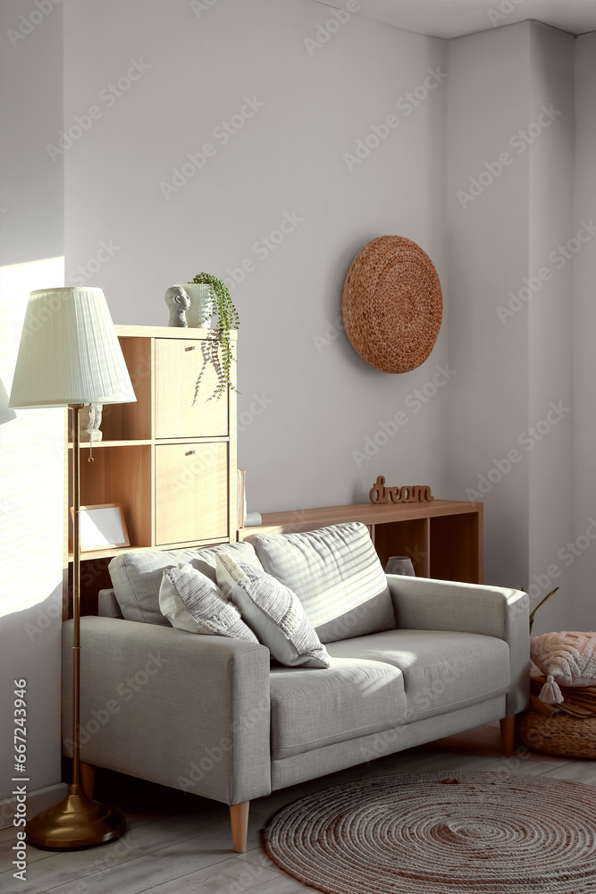 Interior of modern living room with cozy cushions on grey sofa