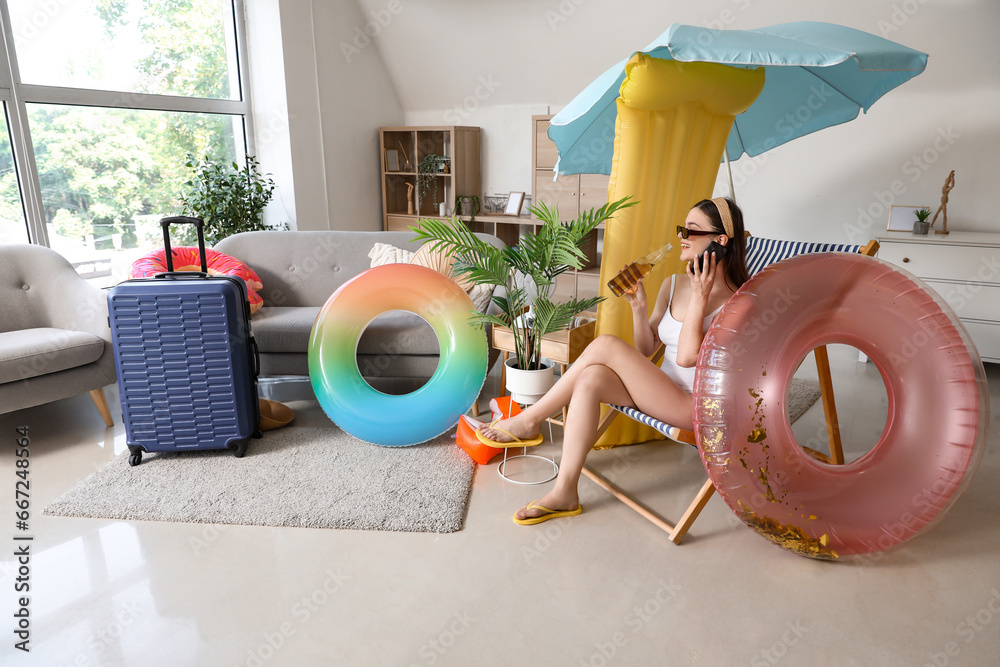 Young woman ready for summer vacation talking by mobile phone at home