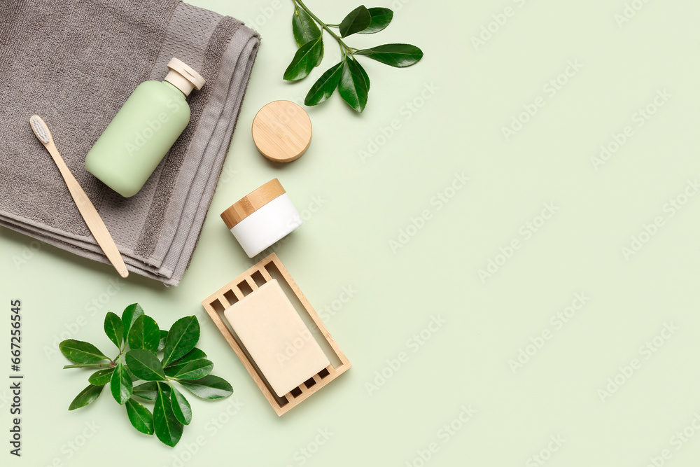 Set of bath supplies with plant branches on color background