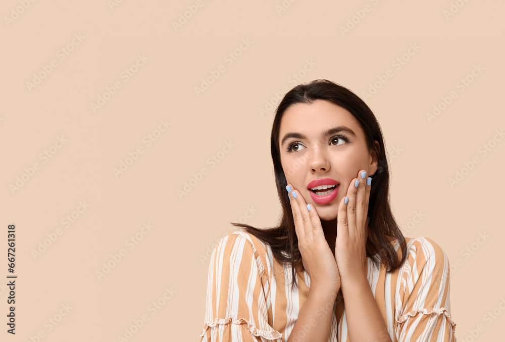 Beautiful young happy woman on beige background