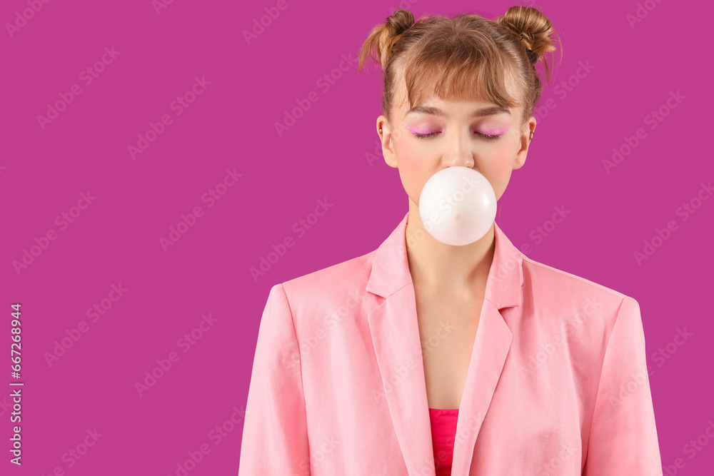 Stylish young woman with chewing gum on purple background