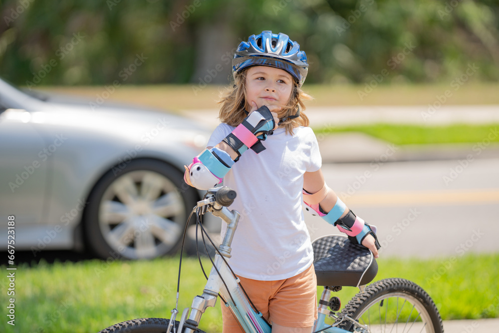 Little kid riding a bike in summer park. Children learning to drive a bicycle on a driveway outside. Kid riding bikes in the city wearing helmets as protective gear. Child on bicycle outdoor.