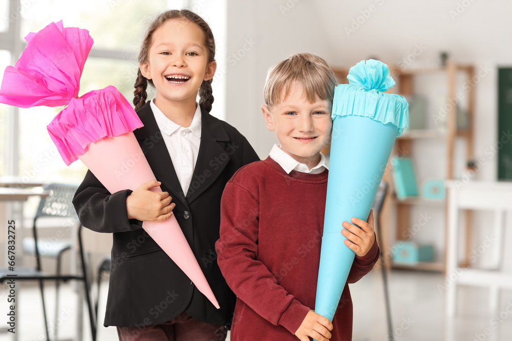 Happy classmates with colorful school cones in classroom