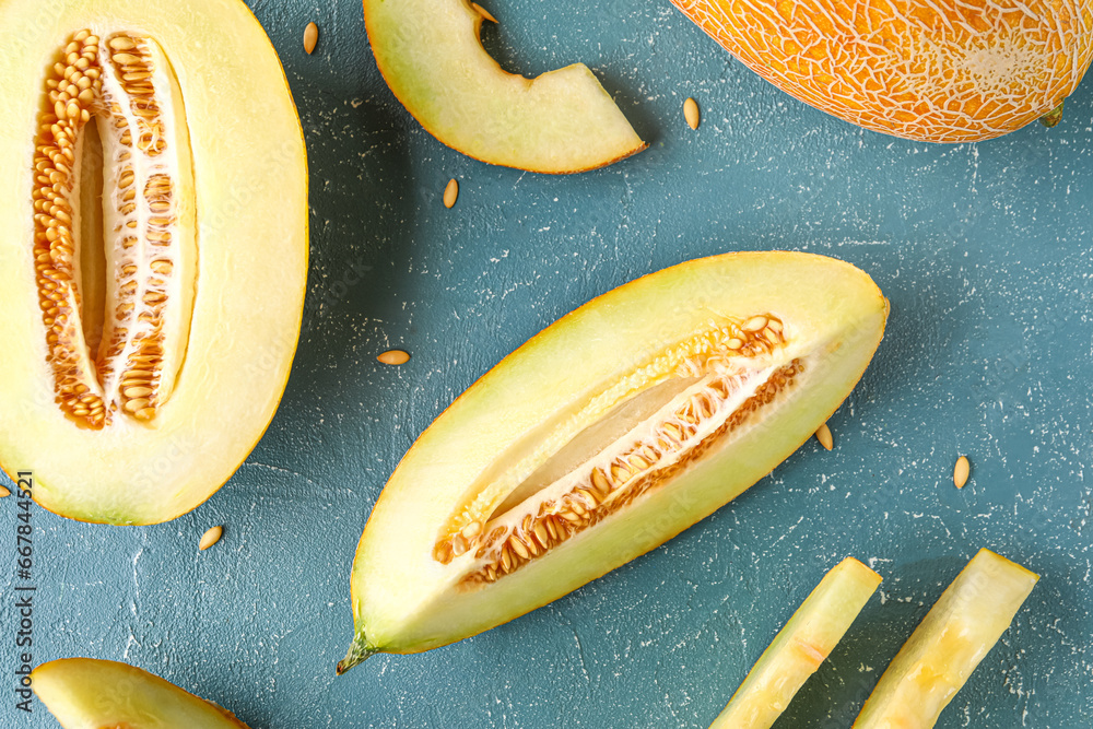 Pieces of sweet melon and seeds on blue background