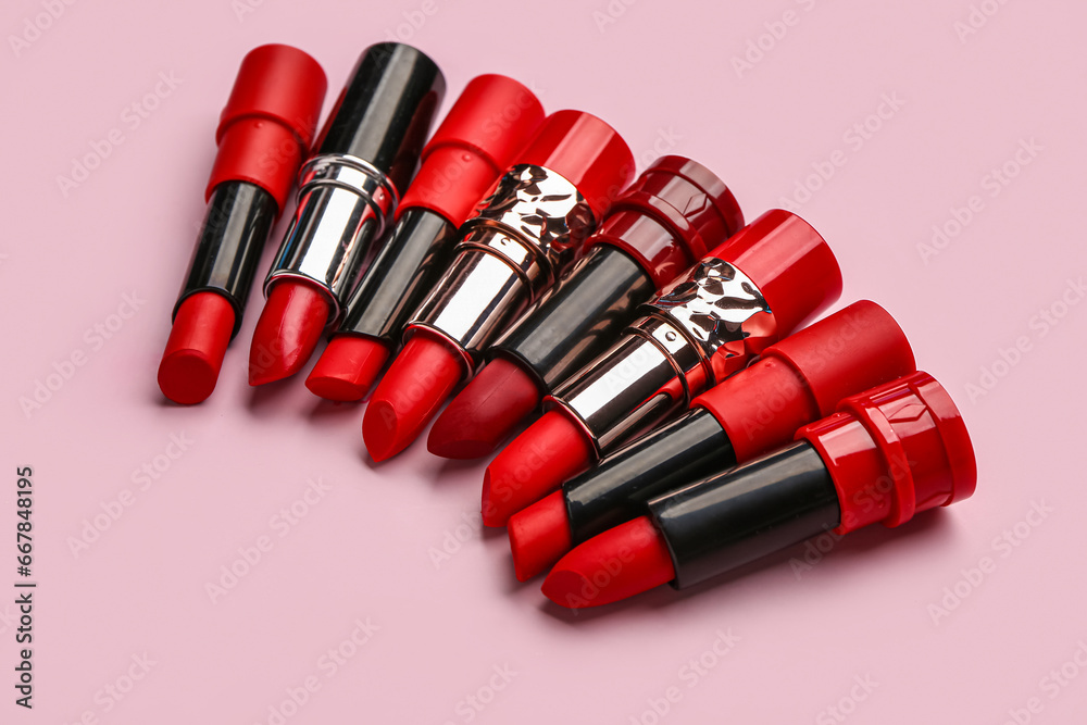 Different bright lipsticks on pink background