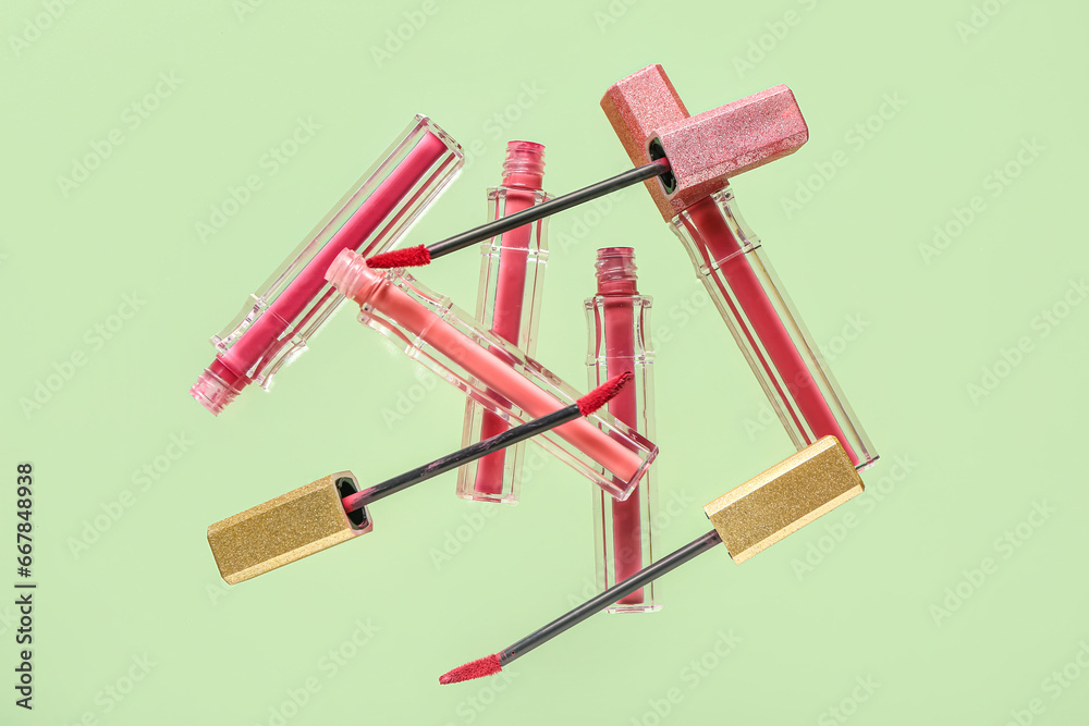 Beautiful lipsticks flying on color background