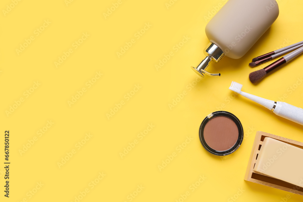 Set of cosmetic products and makeup brushes on color background