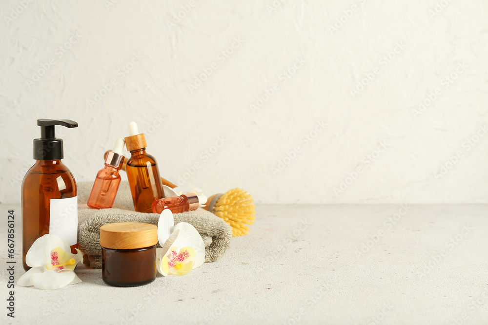 Composition with cosmetic products, bath supplies and orchid flowers on light background