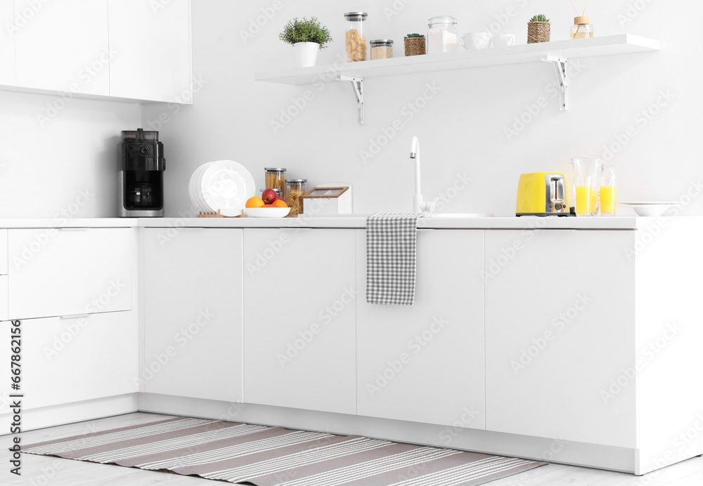 White counters with sink and yellow toaster in interior of modern kitchen