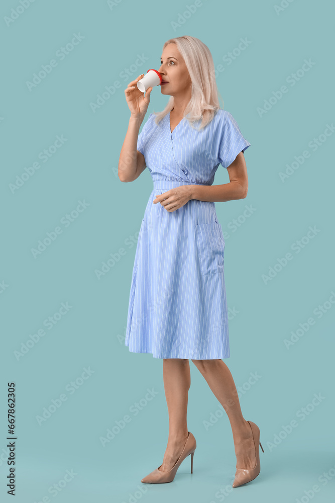 Mature woman drinking coffee on blue background