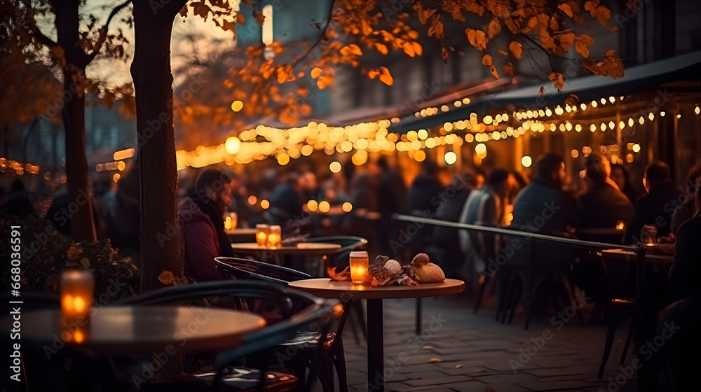 People have dinner in a street restaurant. Evening cafe with a warm garlands.