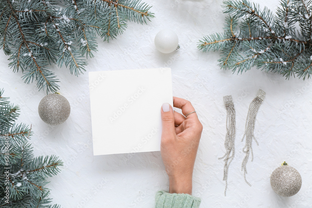 Woman with blank card and Christmas decor on white background