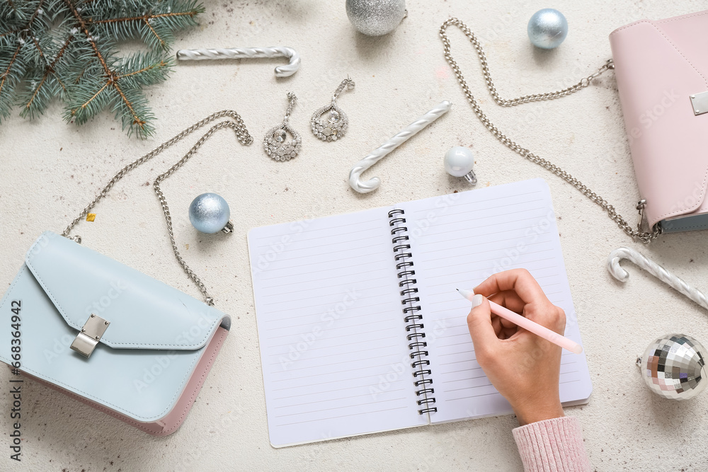 Woman writing in notebook with Christmas decor and accessories on white background