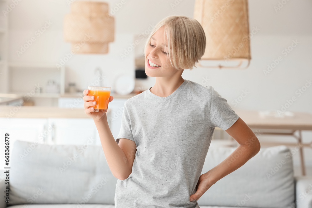 Little boy with glass of juice in kitchen