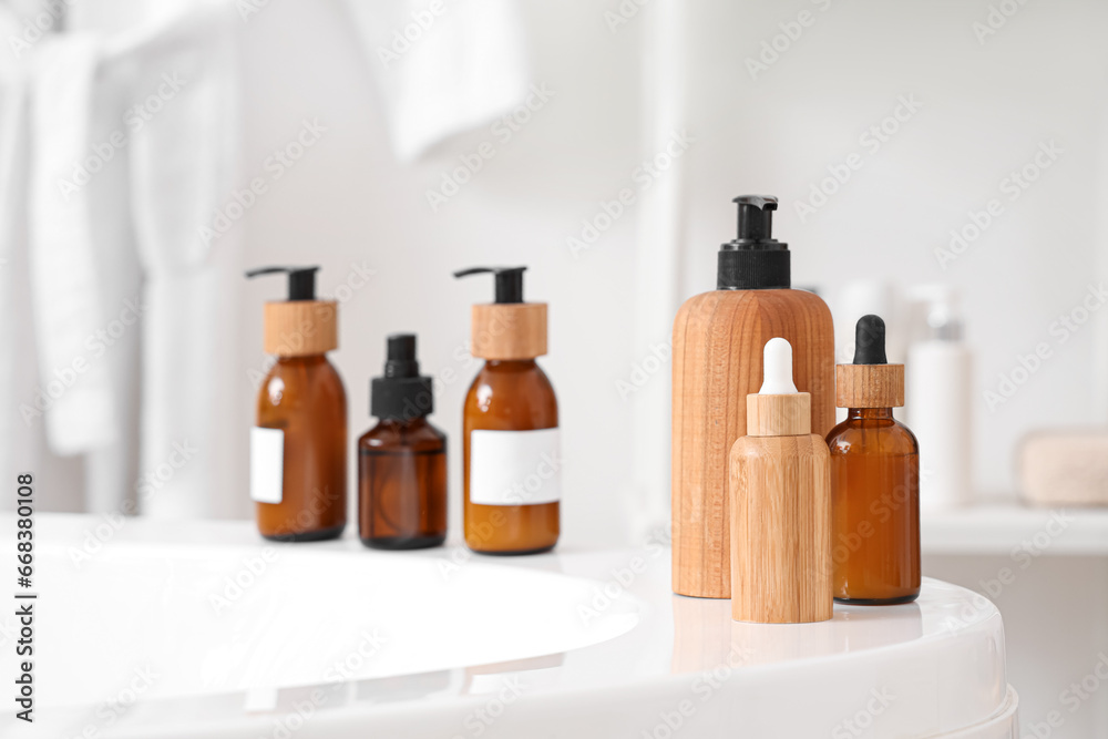 Cosmetic bottles on bathtub in room, closeup