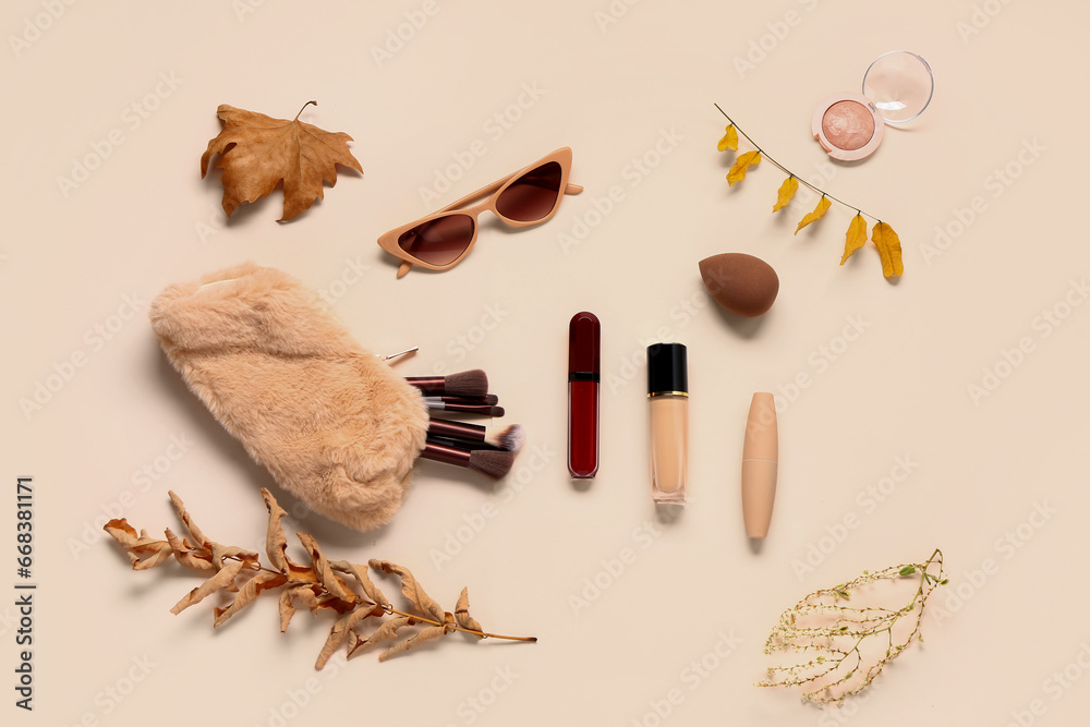 Composition with cosmetic products and autumn leaves on light background