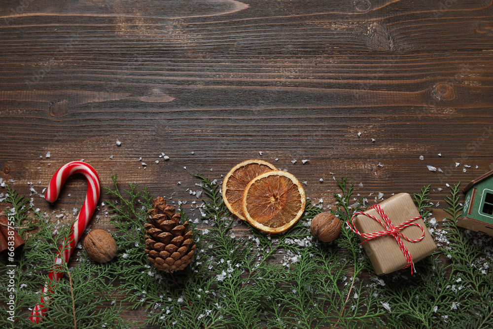 Christmas branches with food and gift on dark wooden background