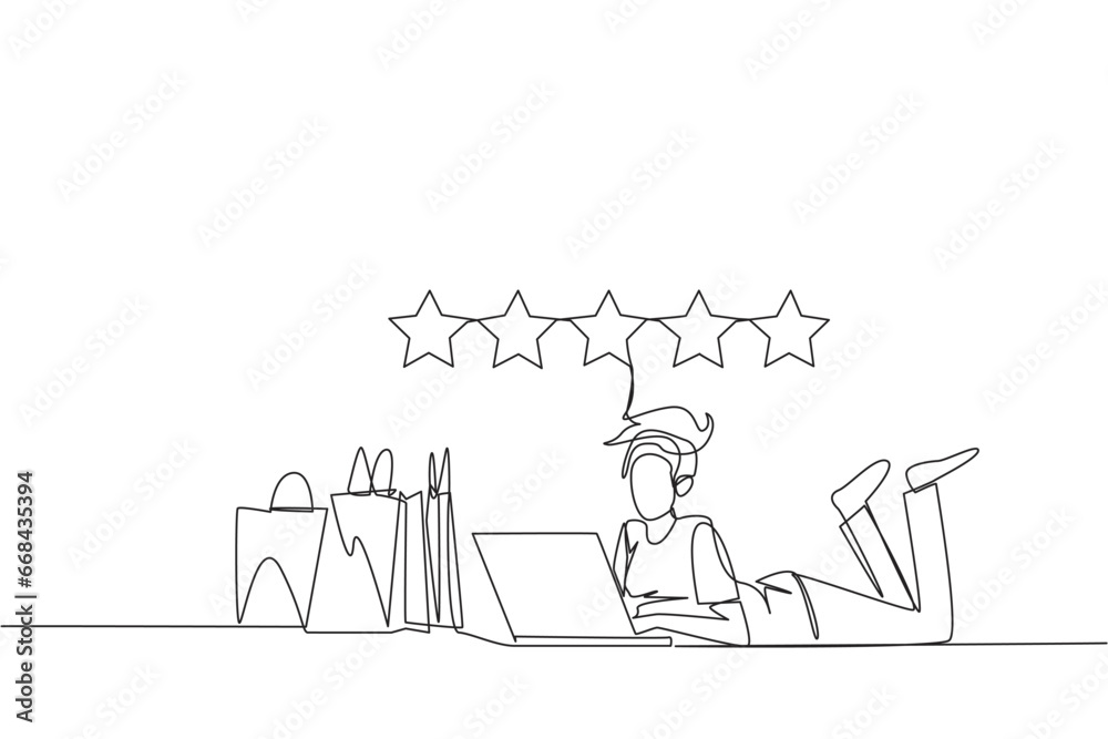 Single continuous line drawing young smiling woman on stomach while typing on laptop. Next to the laptop is a shopping bag. Give the best review with pleasure. One line design vector illustration