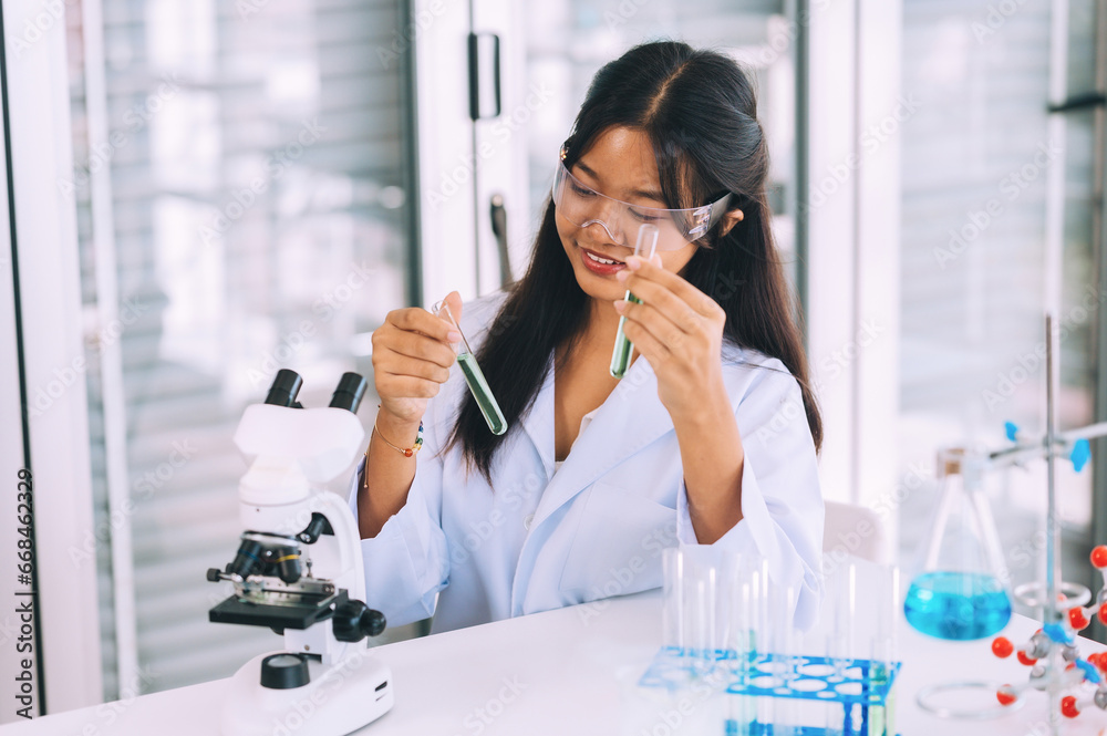 teenage cute little students child learning research and doing a chemical experiment while making analyzing and mixing liquid in test tube at experiment laboratory class at school.Education