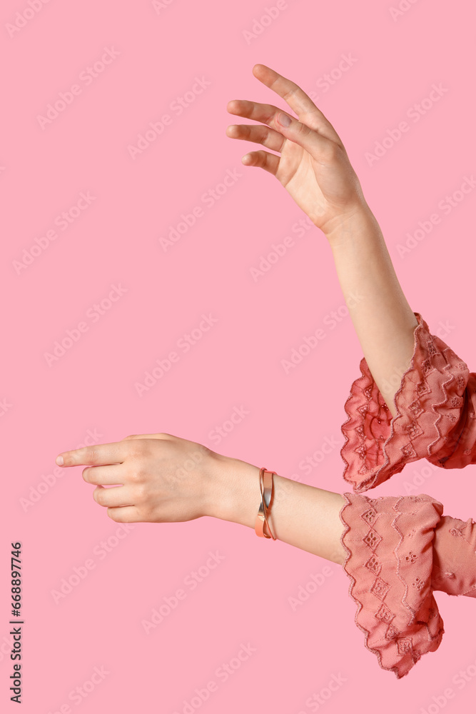 Stylish woman with golden bracelet on pink background