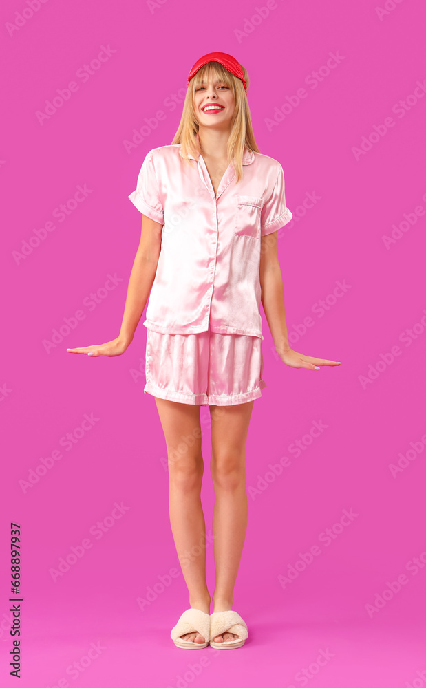 Young woman in pajamas on purple background