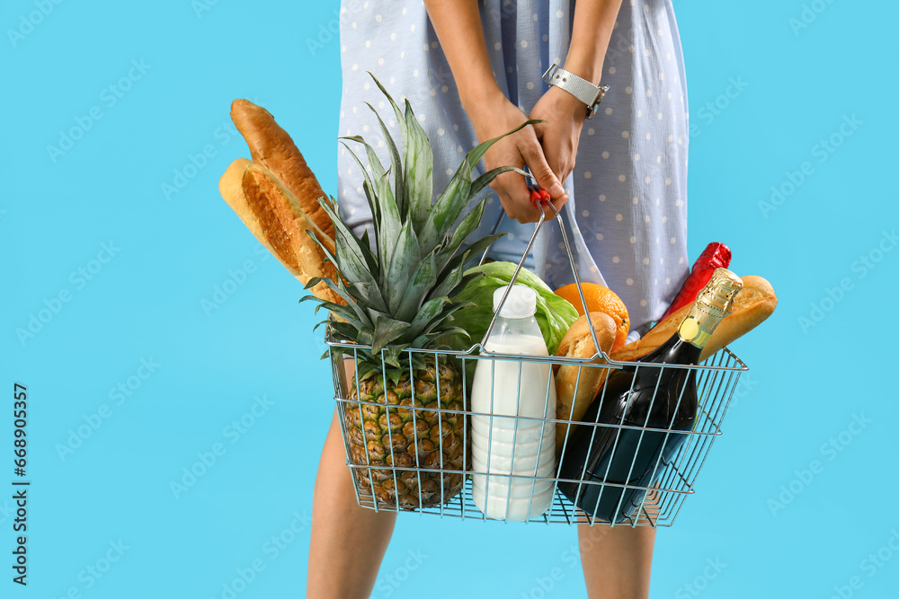 Woman with shopping basket on blue background