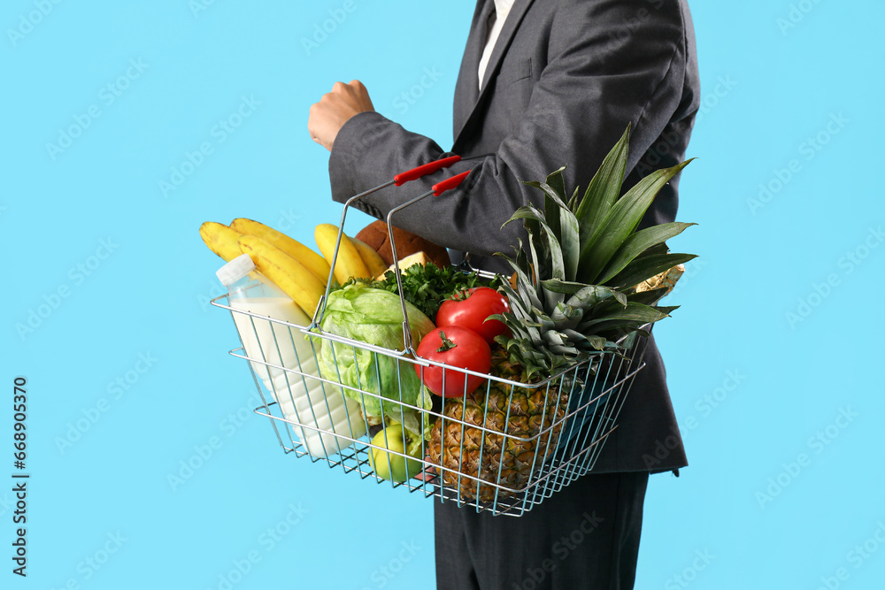 Man with shopping basket on blue background