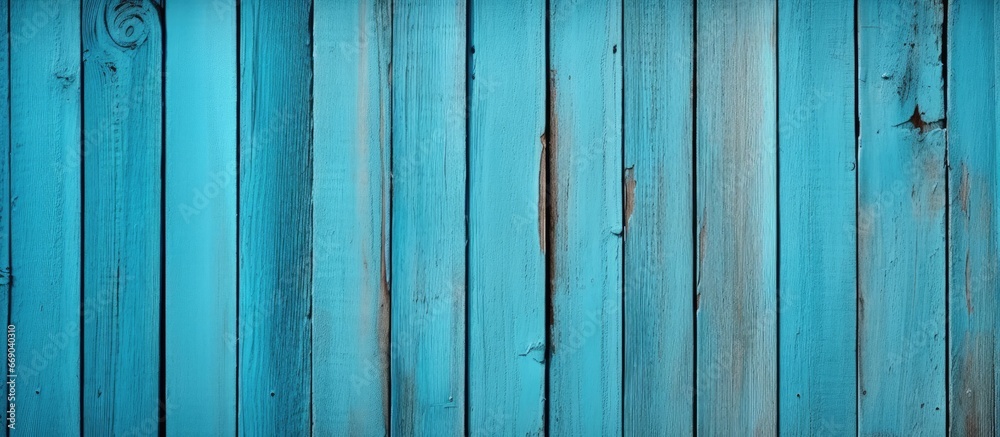 Blue painted wooden fence boards with a turquoise texture in the background