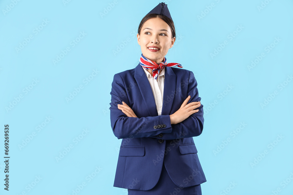 Beautiful Asian stewardess on blue background