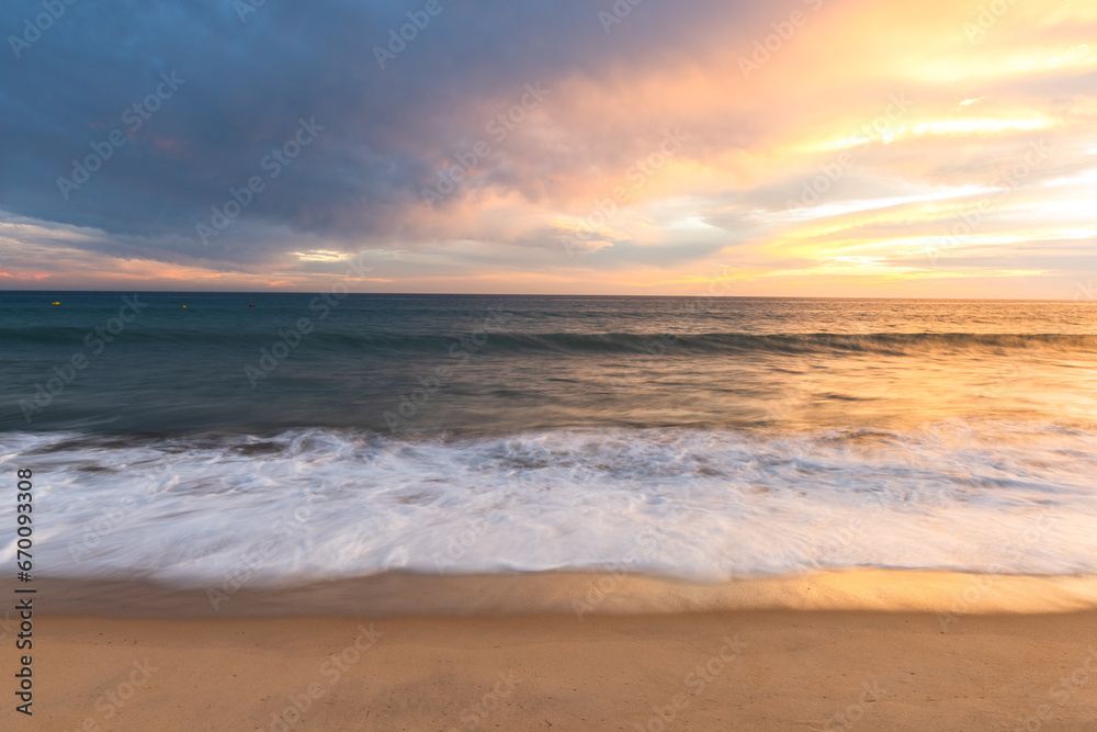 Cloudscape and seascape at ocean sunset with sandy beach in Portugal