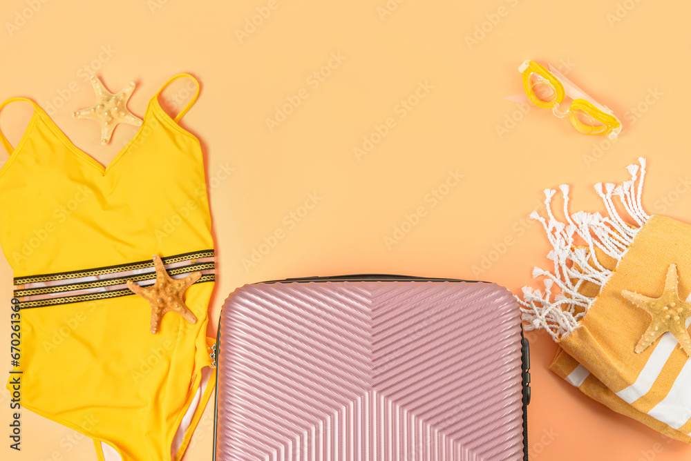 Composition with suitcase and beach accessories on color background