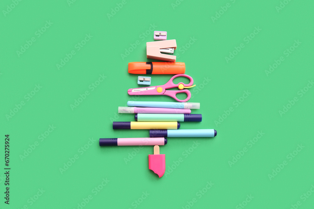 Christmas tree made of stationery on green background