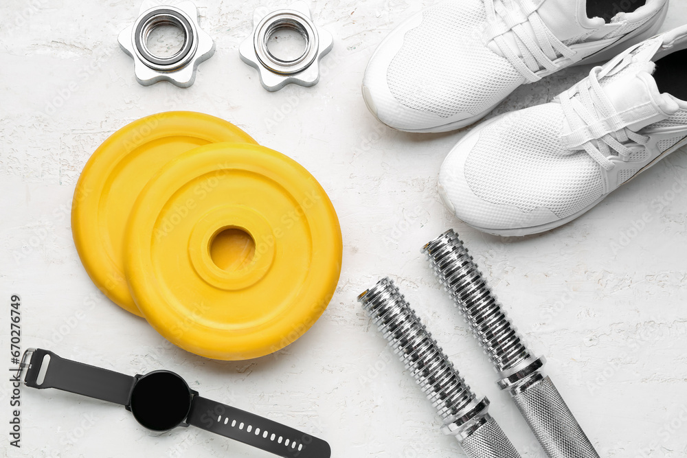 Barbell plates, shoes, watches, grips and clamps on white background