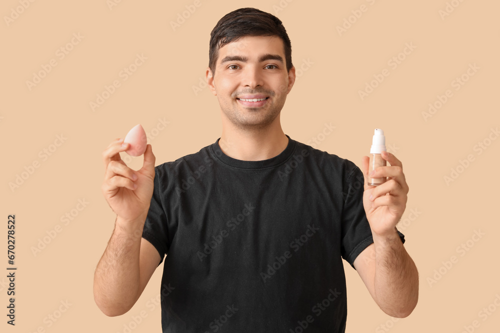 Male makeup artist with foundation and sponge on beige background