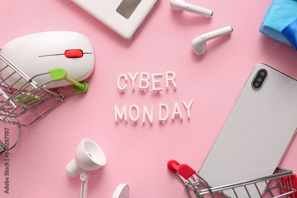 Composition with text CYBER MONDAY and different gadgets on pink background