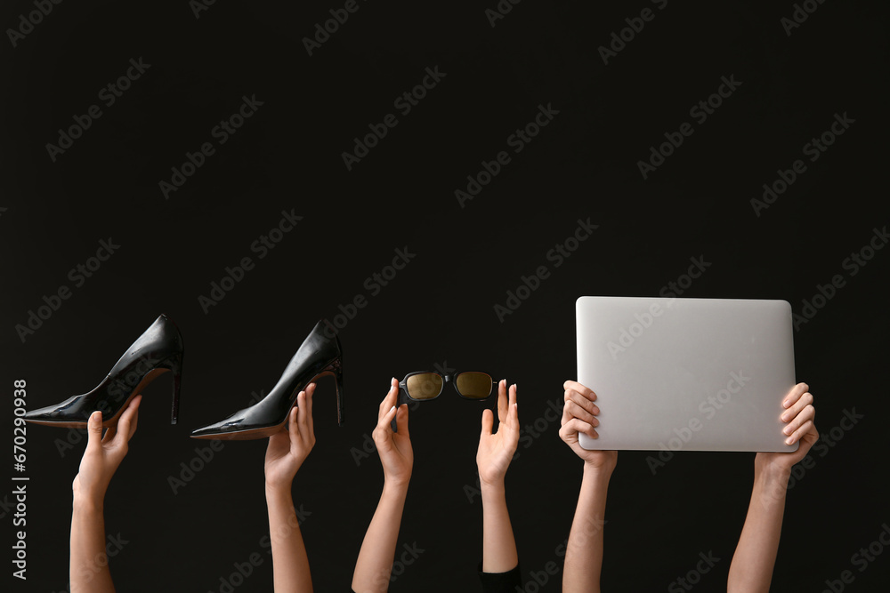 Female hands with women accessories and laptop on dark background. Black Friday sale