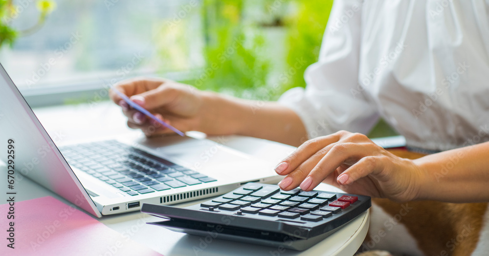 hands with calculator and laptop