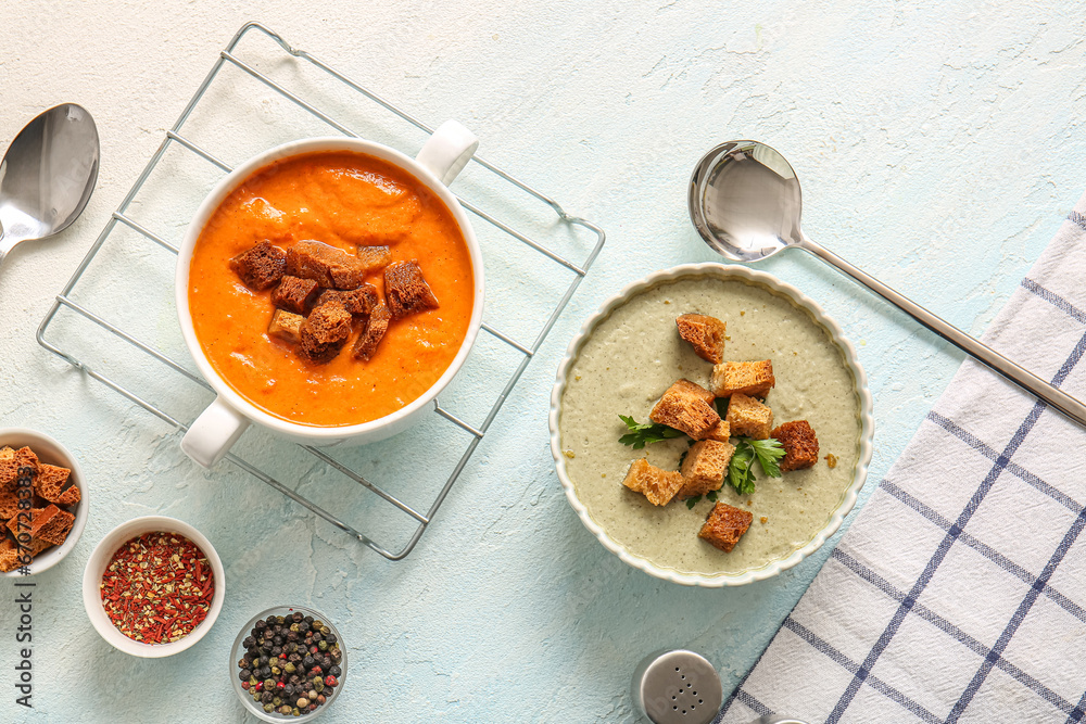 Pot and bowl of tasty cream soup with croutons on white background