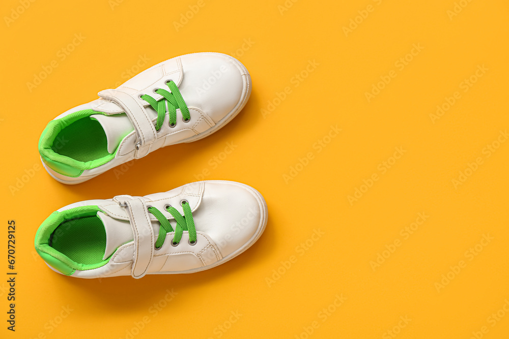 Pair of stylish childs sneakers on color background