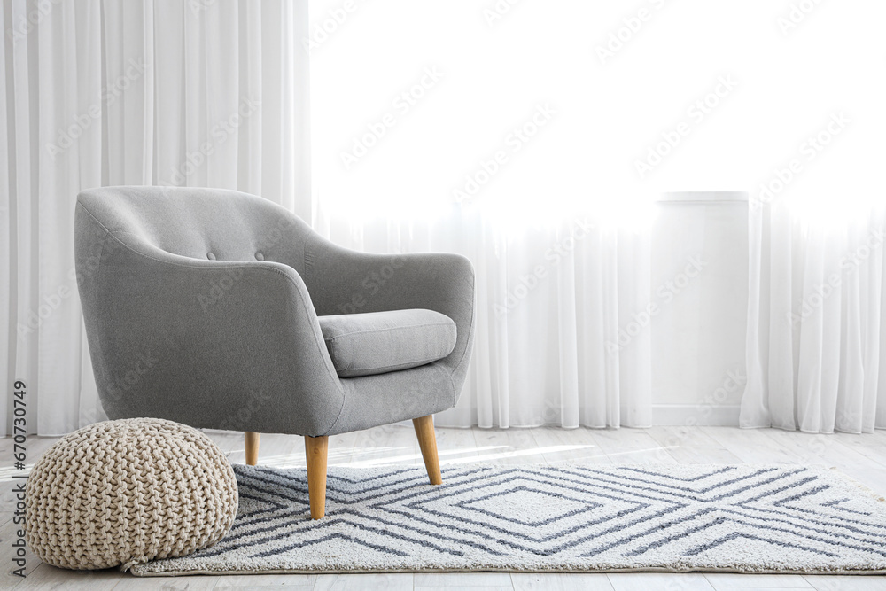 Minimal interior with armchair, carpet and pouf