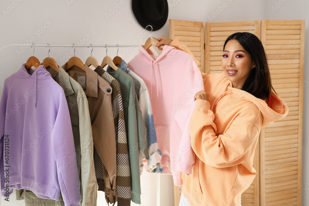 Young Asian woman with stylish hoodie at home