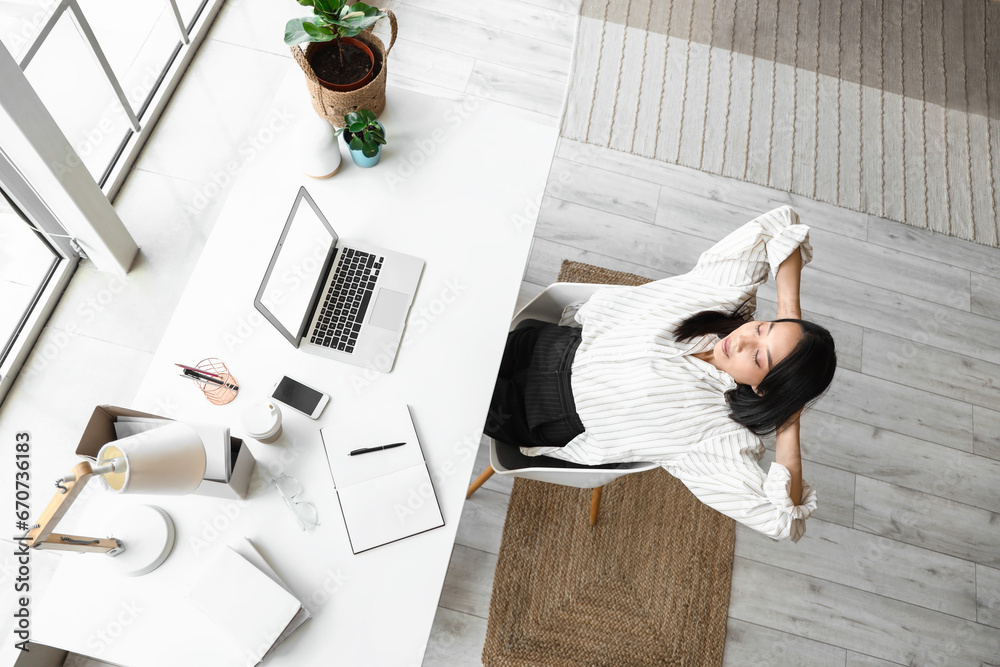 Young Asian woman resting at home office, top view