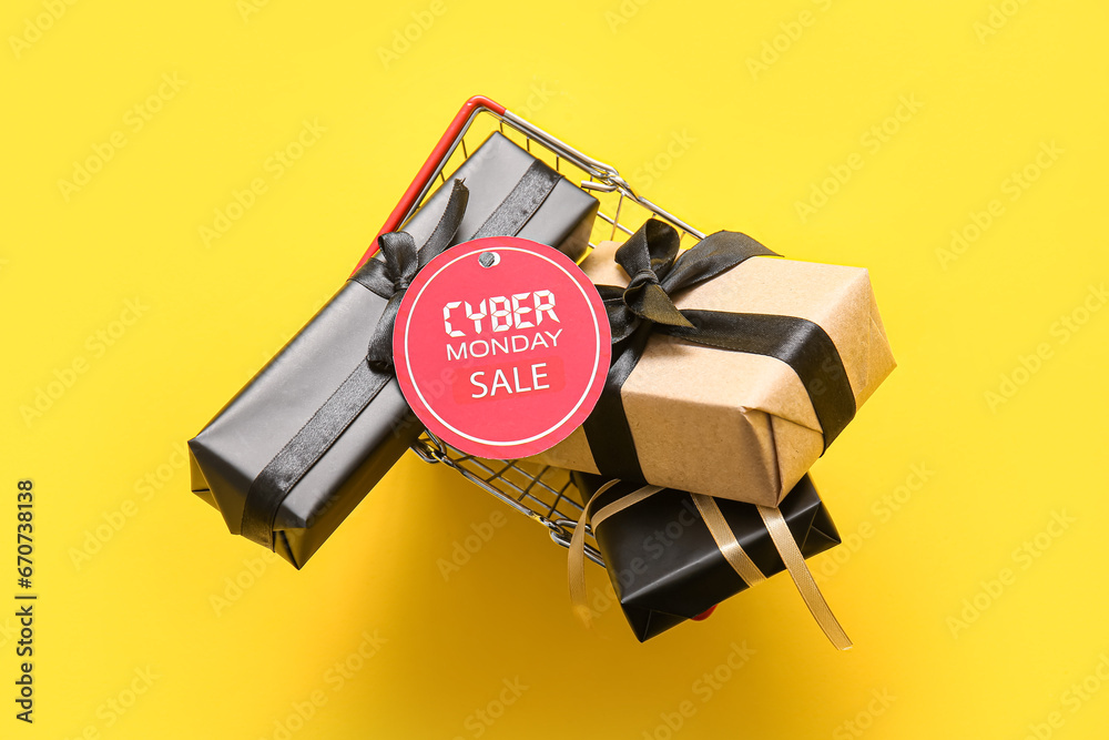 Shopping basket full of gift boxes and tag with text CYBER MONDAY SALe on yellow background