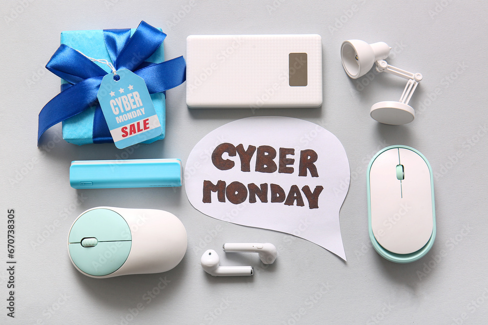 Composition with text CYBER MONDAY, gadgets and gift box on grey background