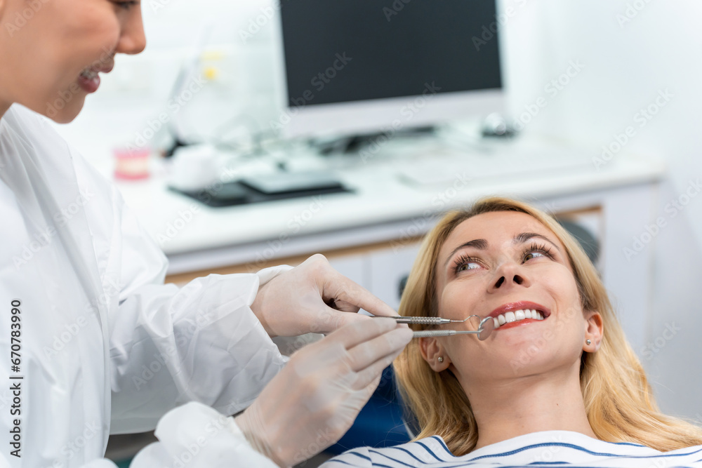 Female dentist examine tooth to Caucasian girl at dental health clinic. 