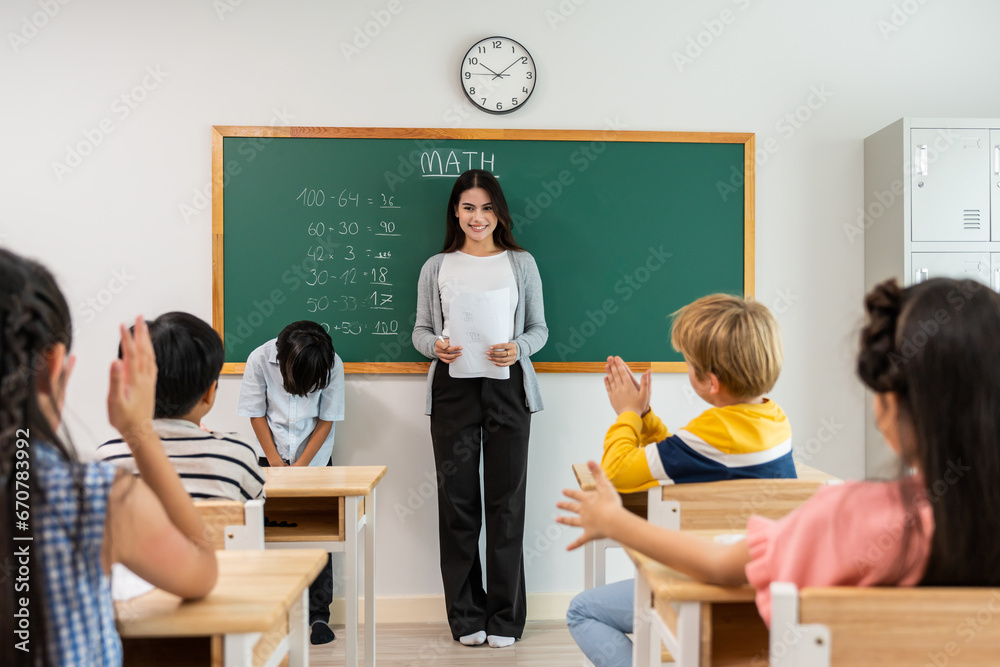 Group of student learn with teacher in classroom at elementary school. 