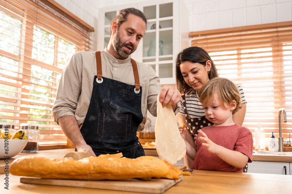 Caucasian attractive couple baking bakery with son in kitchen at home. 