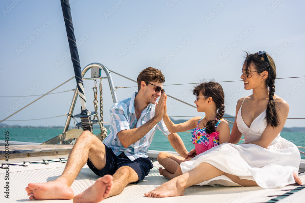 Caucasian happy family sitting on deck of yacht while yachting outdoor. 