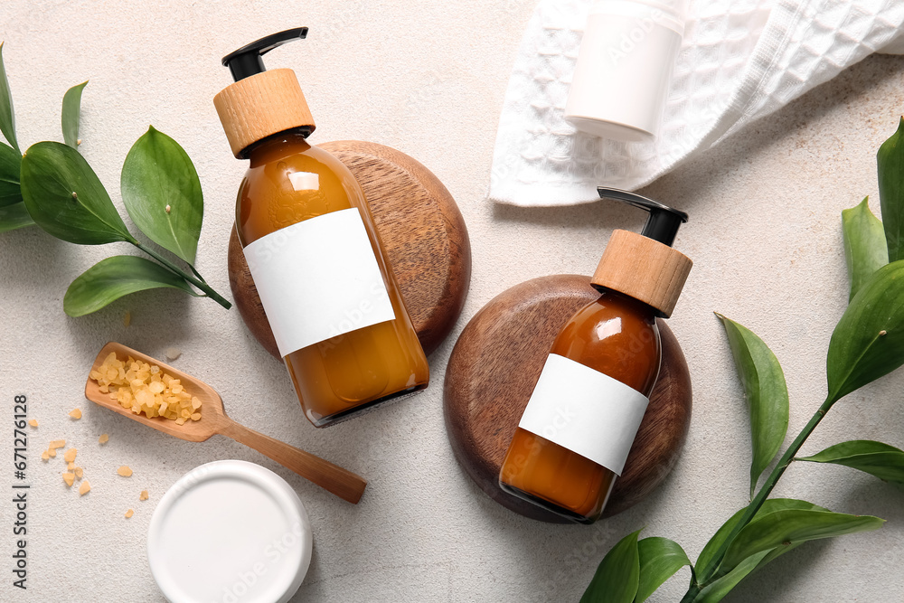 Bottles of shampoo, sea salt and cosmetic products on white background