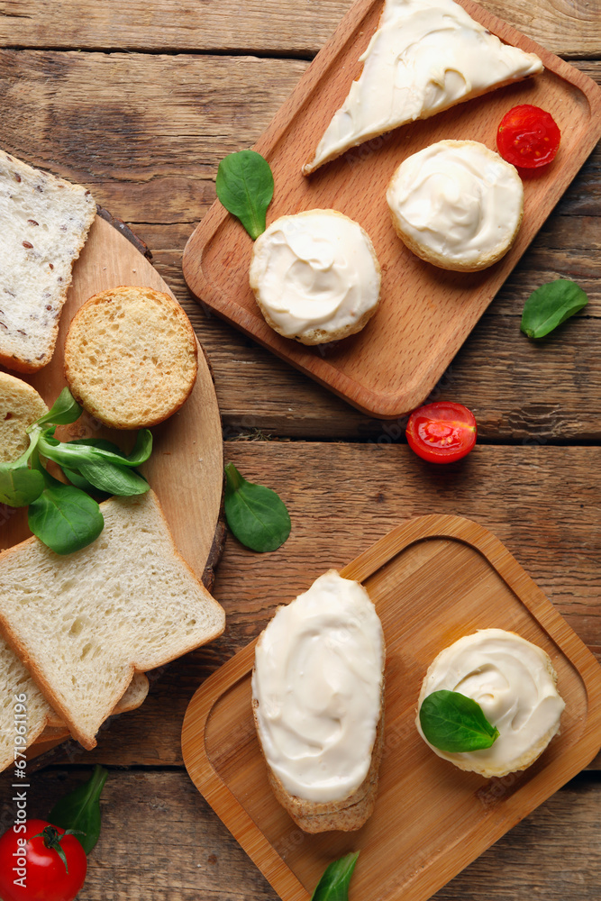 Boards of tasty bruschetta and croutons with cream cheese on wooden background